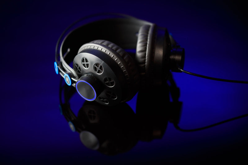Black over-ear headphones commercial product shot on dark reflective surface